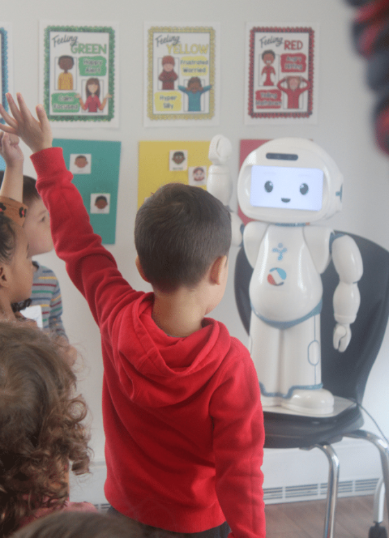 3 children holding up their hands to engage with robot